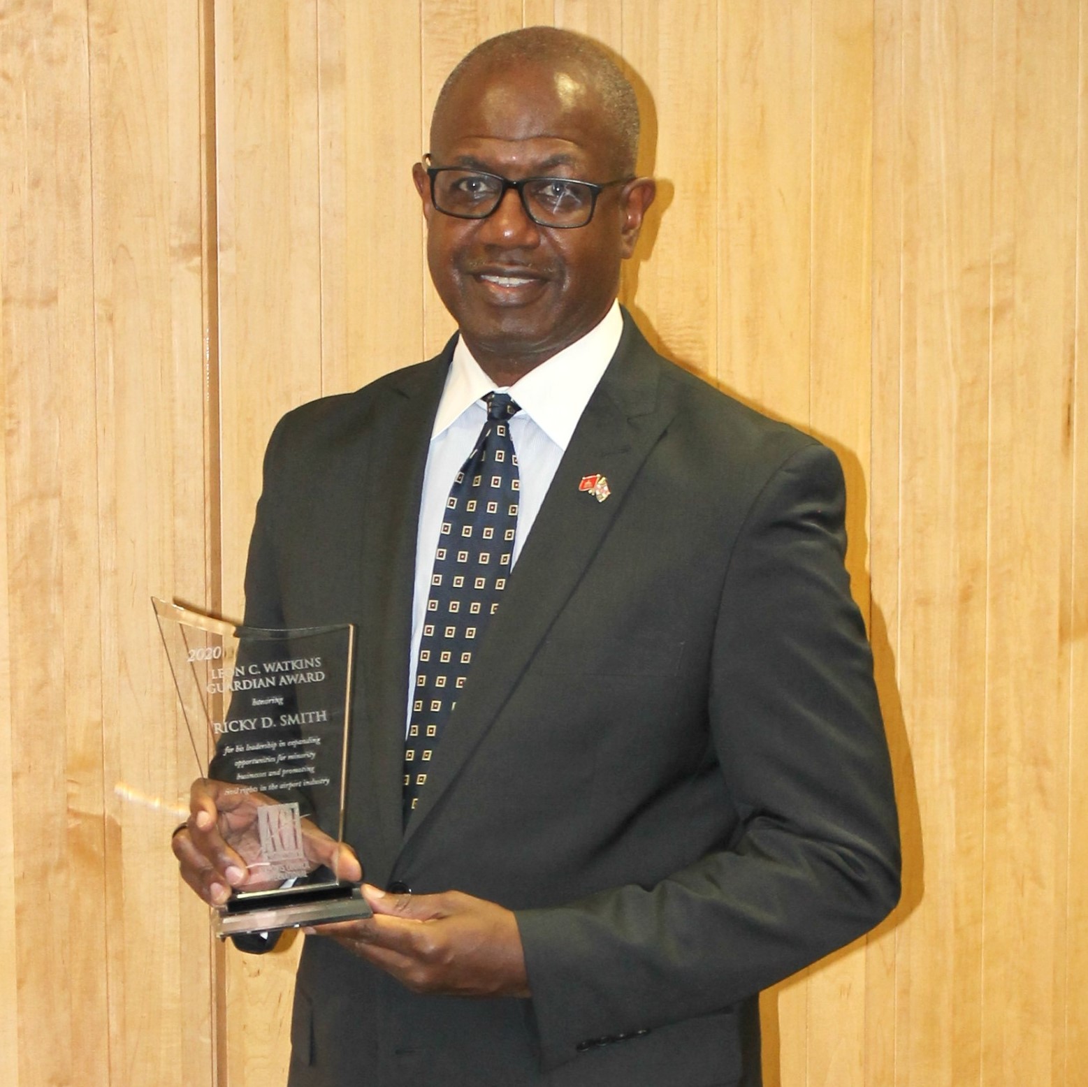 Photograph of Ricky Smith holding ACI-NA Leon C. Watkins Guardian Award trophy