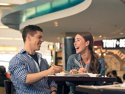 Young couple eating sushi at a restaurant in Concourse A at BWI Marshall Airport