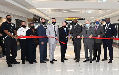 Photo of Governor Hogan, Ricky Smith and others taking part in a ribbon cutting ceremony to celebrate the opening of the Concourse A extension at BWI Marshall Airport