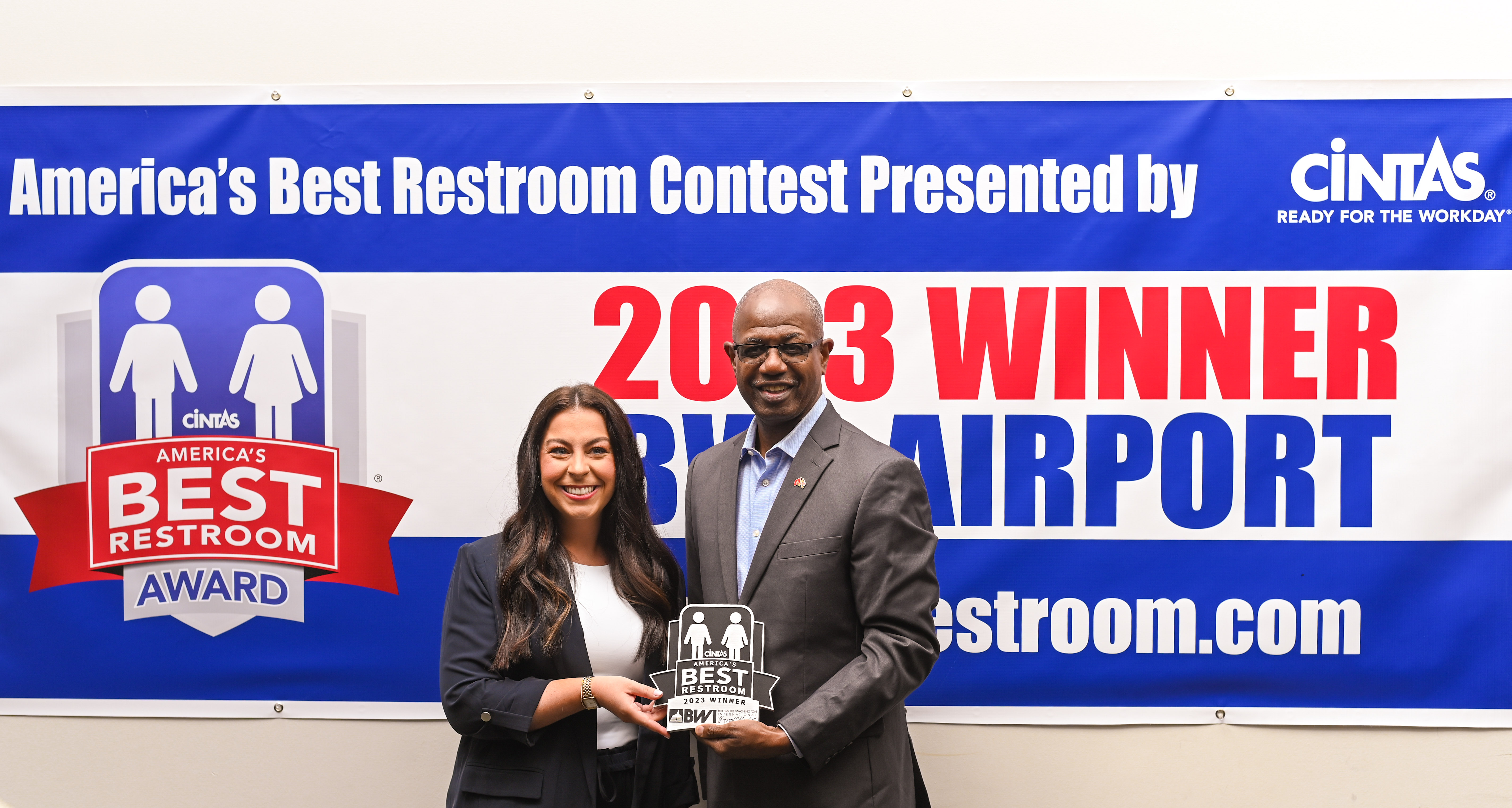 Photo of a Cintas Corporation representative and Maryland Aviation Administration Executive Director/CEO Ricky Smith holding an award plaque recognizing BWI Marshall Airport as the winner of the 2023 America's Best Restroom Award