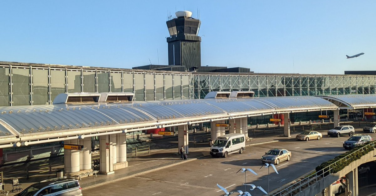 Photo overlooking the Departures Level roadway at BWI Marshall Airport with a departing aircraft in the background.