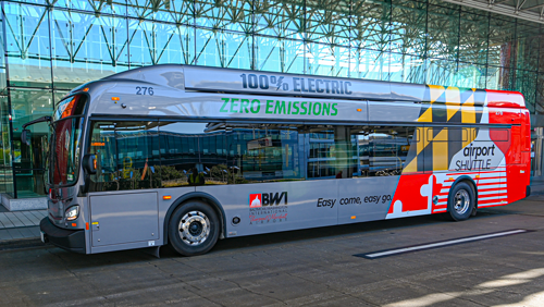 Photo of a zero-emissions parking shuttle parked on a terminal roadway in front of BWI Marshall Airport.