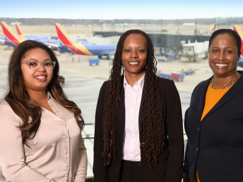 Photo of 3 Maryland Aviation Administration employees pictured in the BWI Marshall Airport Observation Gallery with aircraft in the background.