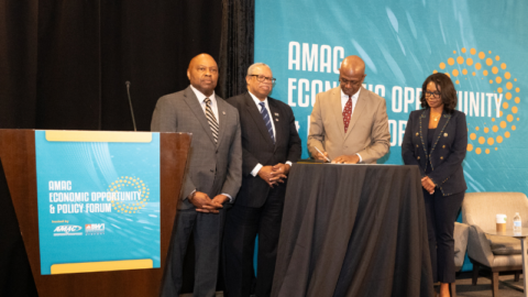 Photo from the Airport Minority Advisory Council Economic Opportunity and Policy Forum of Ricky Smith signing the Equity in Infrastructure Project Pledge as 3 others look on.