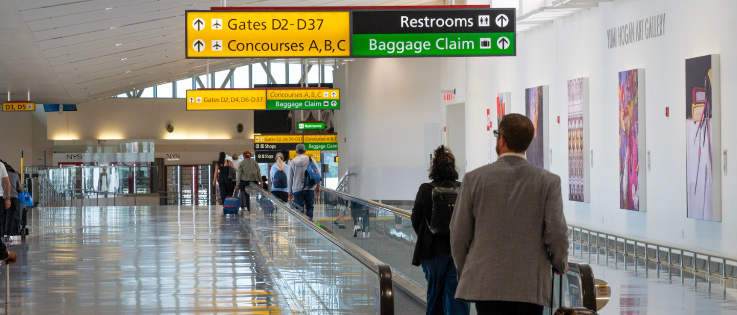 Photo of passengers walking past an art wall in Concourse D at BWI Marshall Airport.