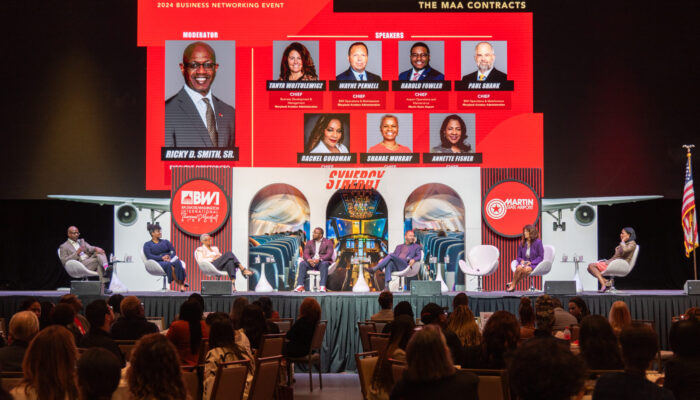 Photo showing Maryland Aviation Administration Executive Management Team members on stage participating in a panel discussion at the 2024 SynergyBWI Business and Networking Event.