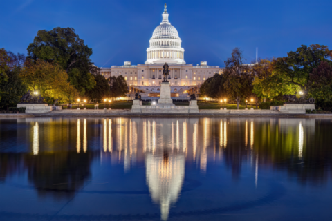 A nighttime photo of the U.S. Capitol building reflecting from the Capitol Reflecting Pool