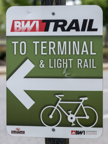 Photo of a sign indicating the BWI Trail directing users toward the airport terminal and light rail station.