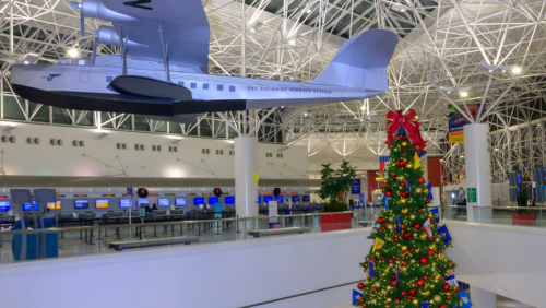 Photo of an overhead replica aircraft and a large tree with holiday decorations on display   at BWI Thurgood Marshall Airport