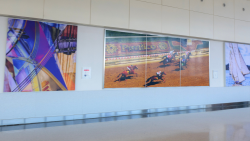 A 3-panel panorama of Pimlico Race Course and 2 canvas prints on display within the B/C Connector at BWI Thurgood Marshall Airport.