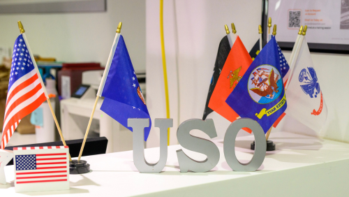 Block letters spelling USO with flags representing the United States and various branches of the military on a counter inside the USO at BWI Thurgood Marshall Airport.