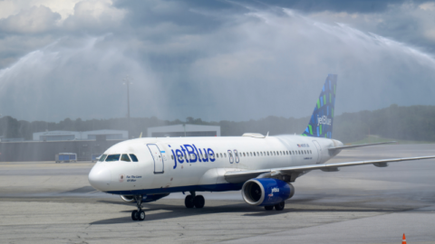 A JetBlue aircraft taxis beneath a water salute at BWI Thurgood Marshall Airport.